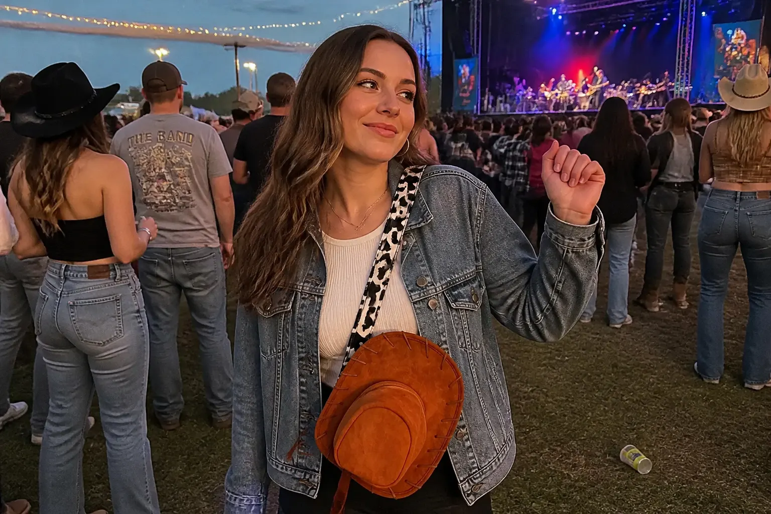 Woman wearing the cowboy hat bag crossbody at a country concert