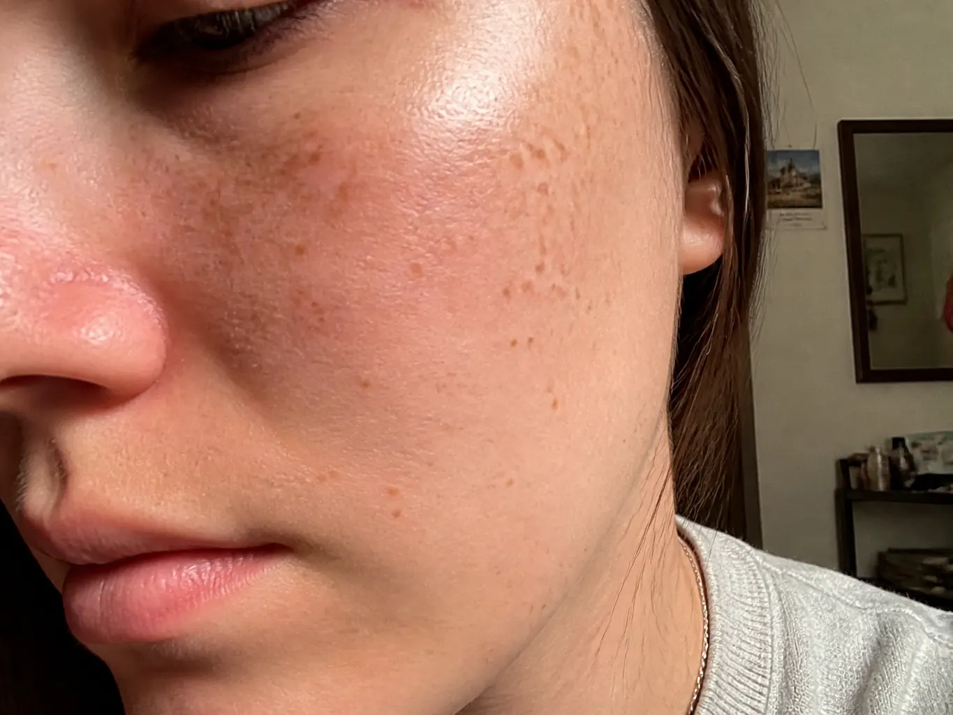 Extreme close-up of the irregular printed freckle dots on the sheet next to the same dots on skin