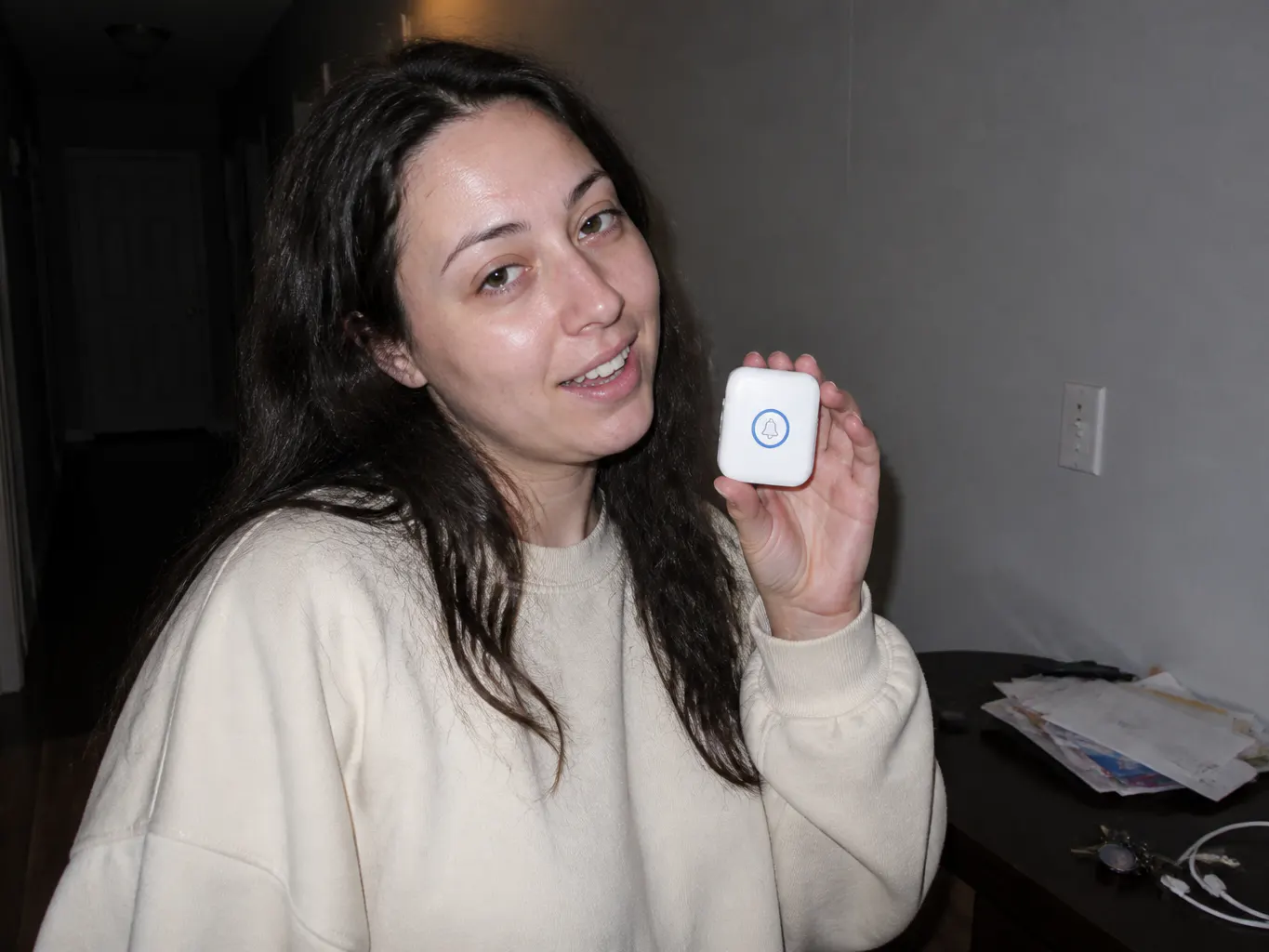 A mother taking a casual selfie holding the small white button