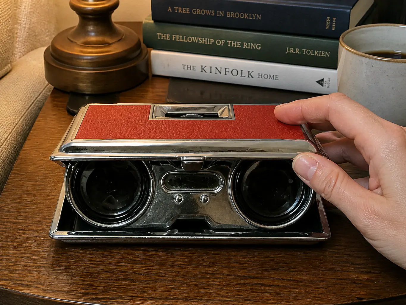 The hinged lid halfway open, eyepieces emerging