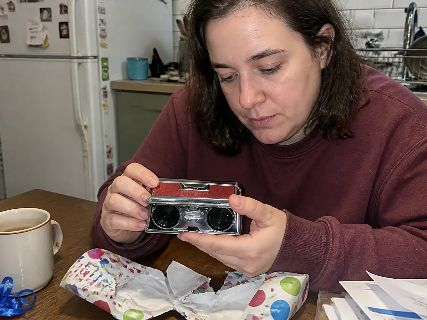 The closed camera-shaped case held in a palm in front of a theatre lobby