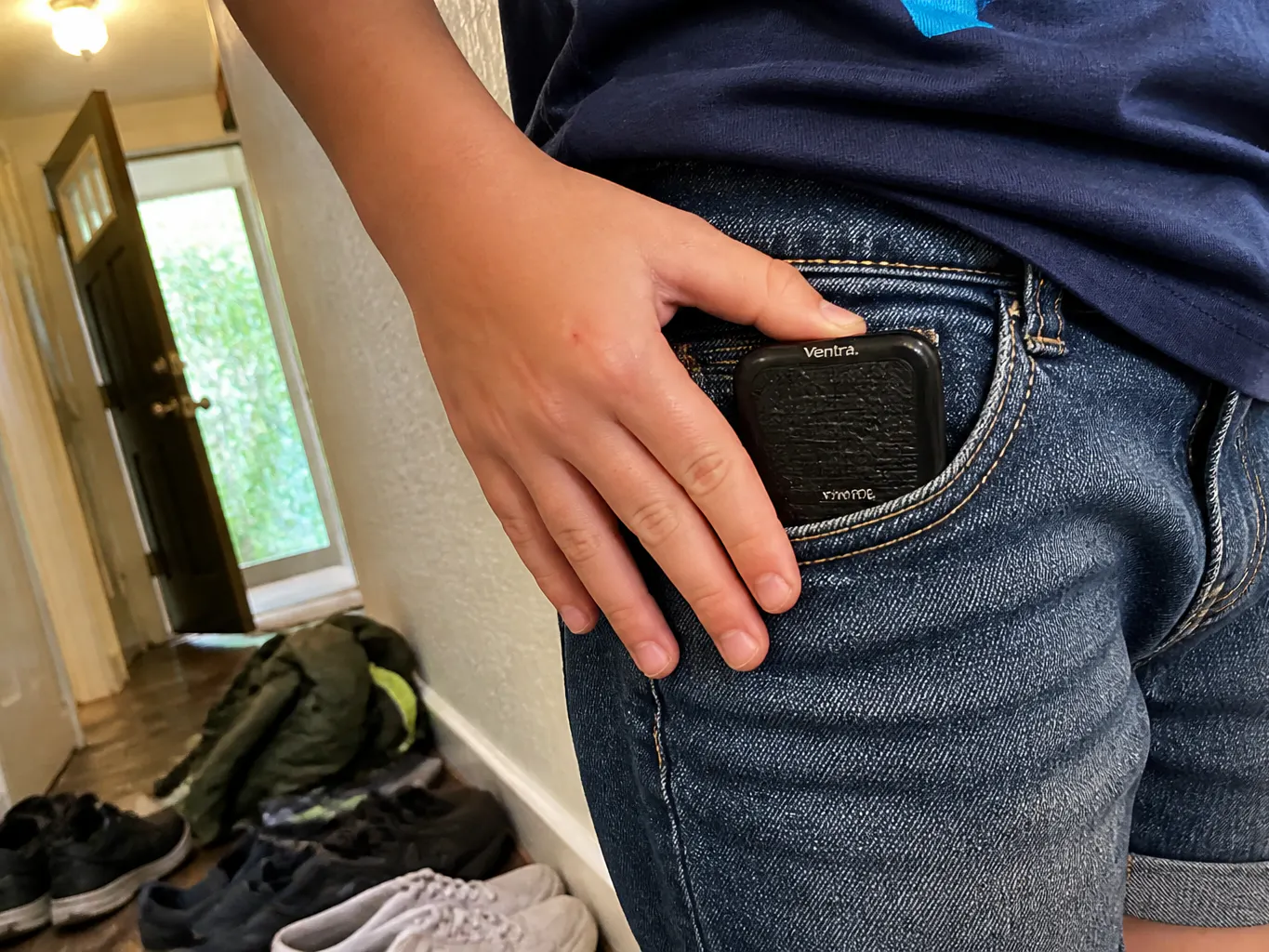 The folded case sliding into a child's jacket pocket