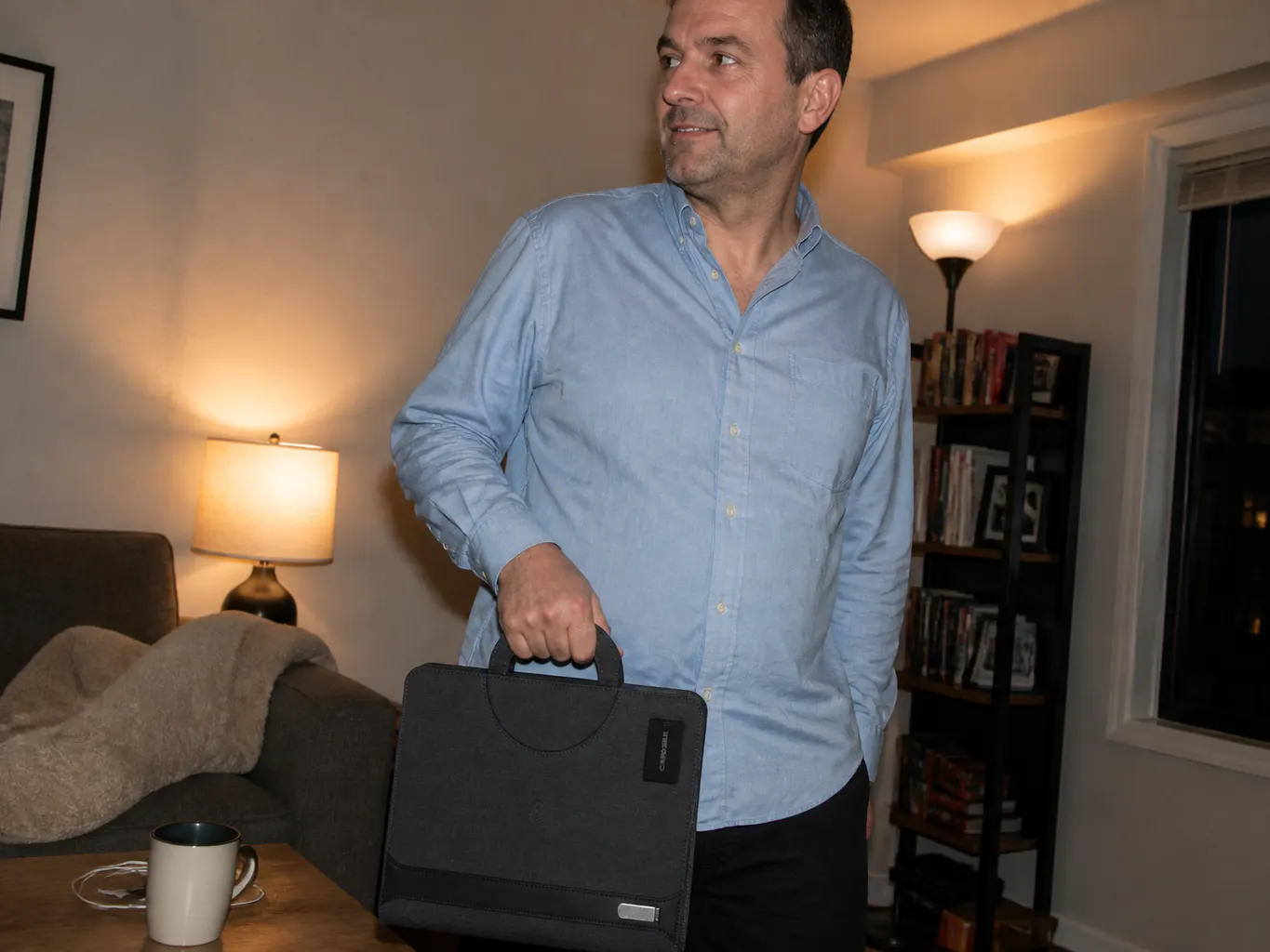 The padfolio open on a meeting table with a phone charging on the panel
