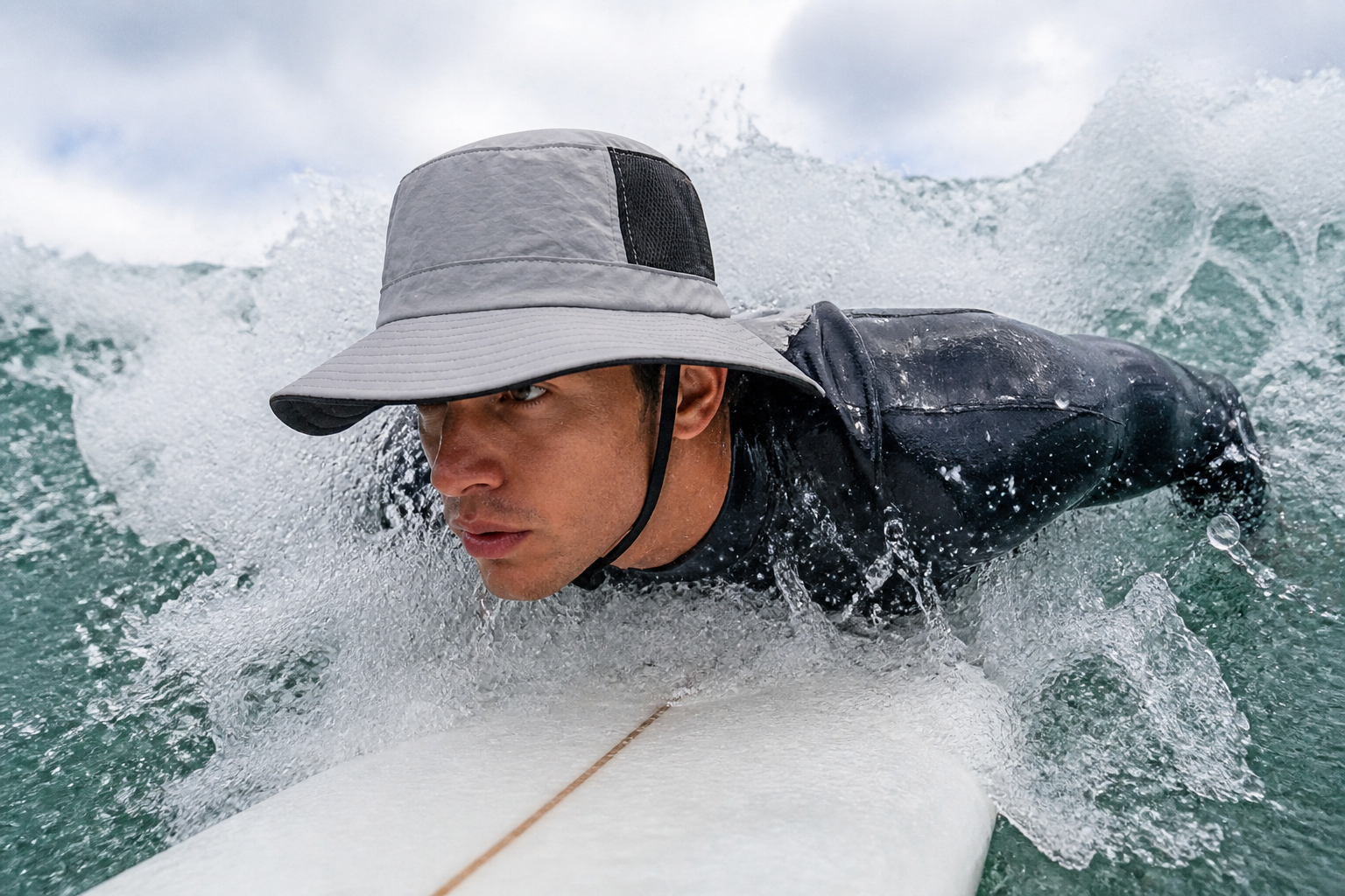 Surfer surfacing after a wipeout with the hat still on