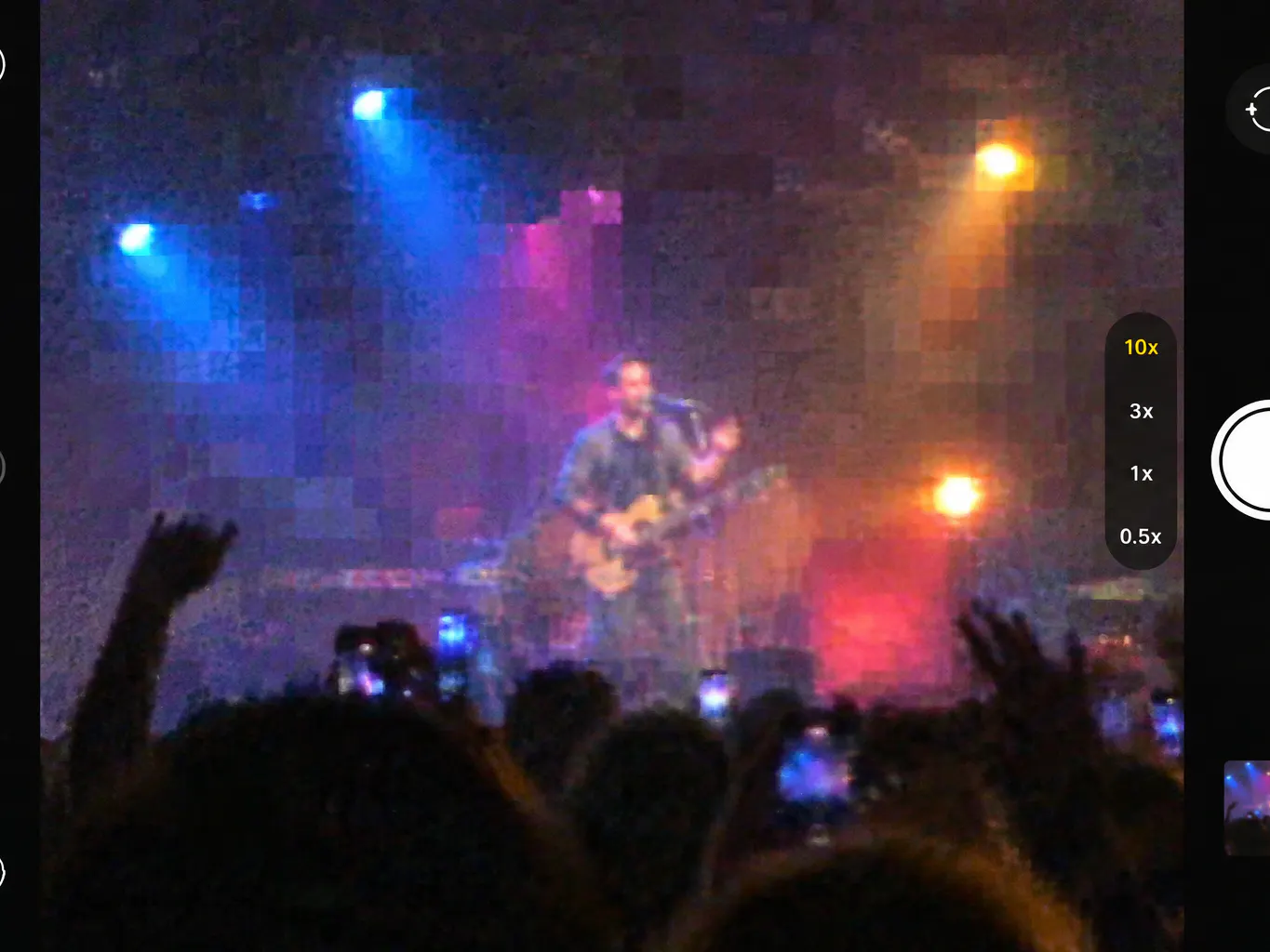Person photographing a concert stage with a phone fitted with the ZoomScope lens