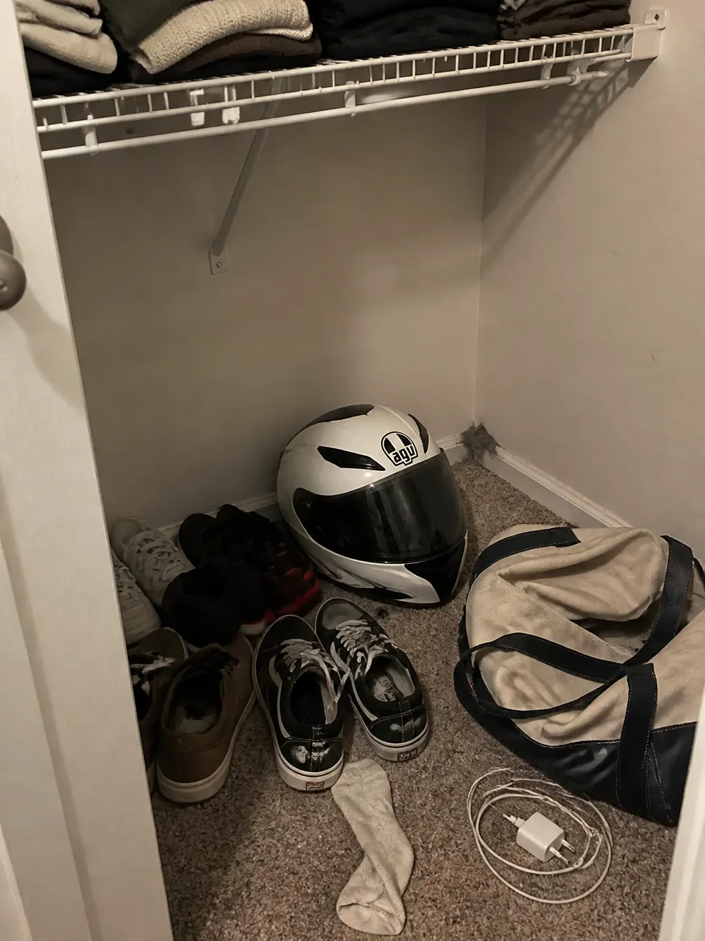 A motorcycle helmet dumped on a cluttered workbench
