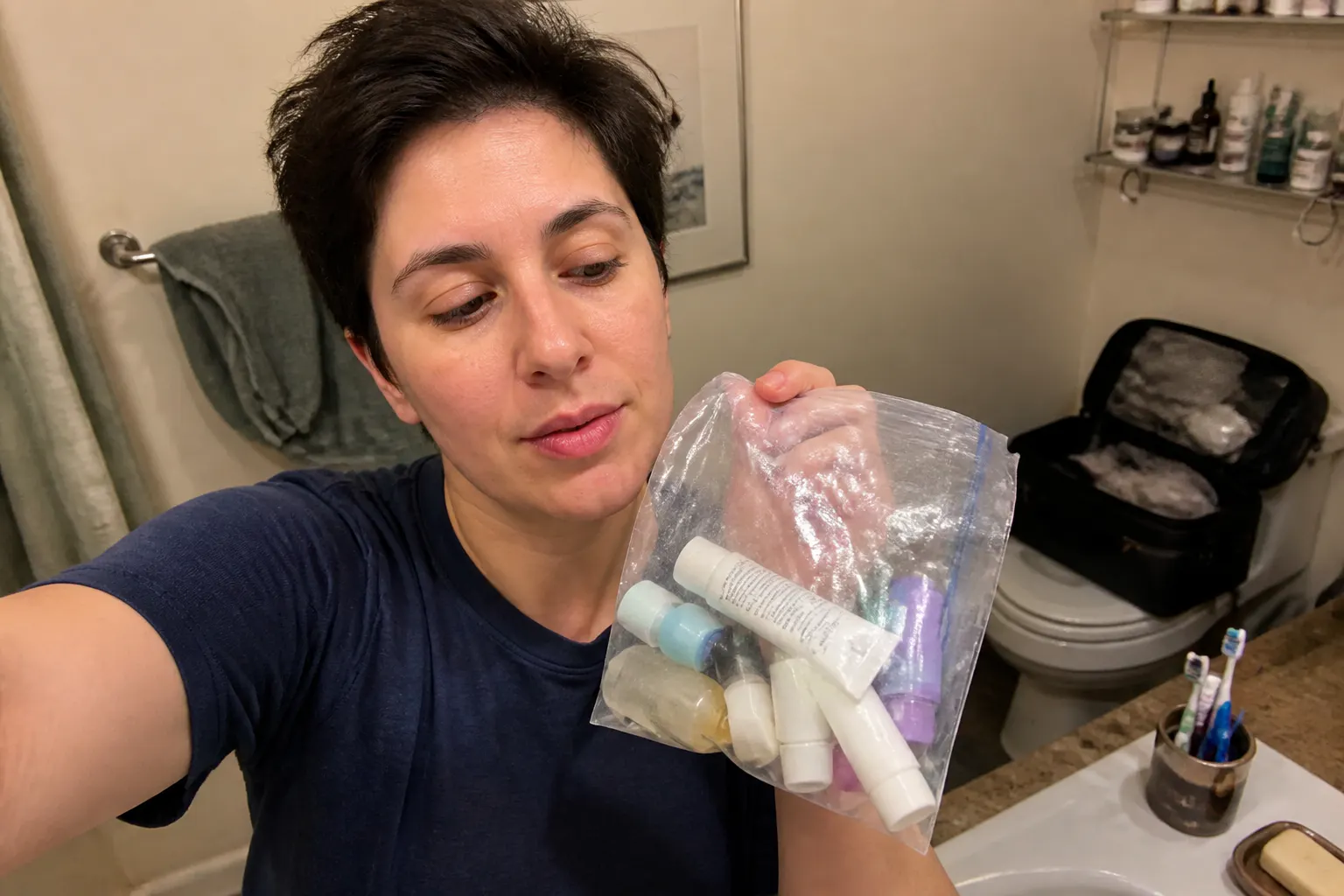 A scattered ziplock of mismatched leaking travel bottles