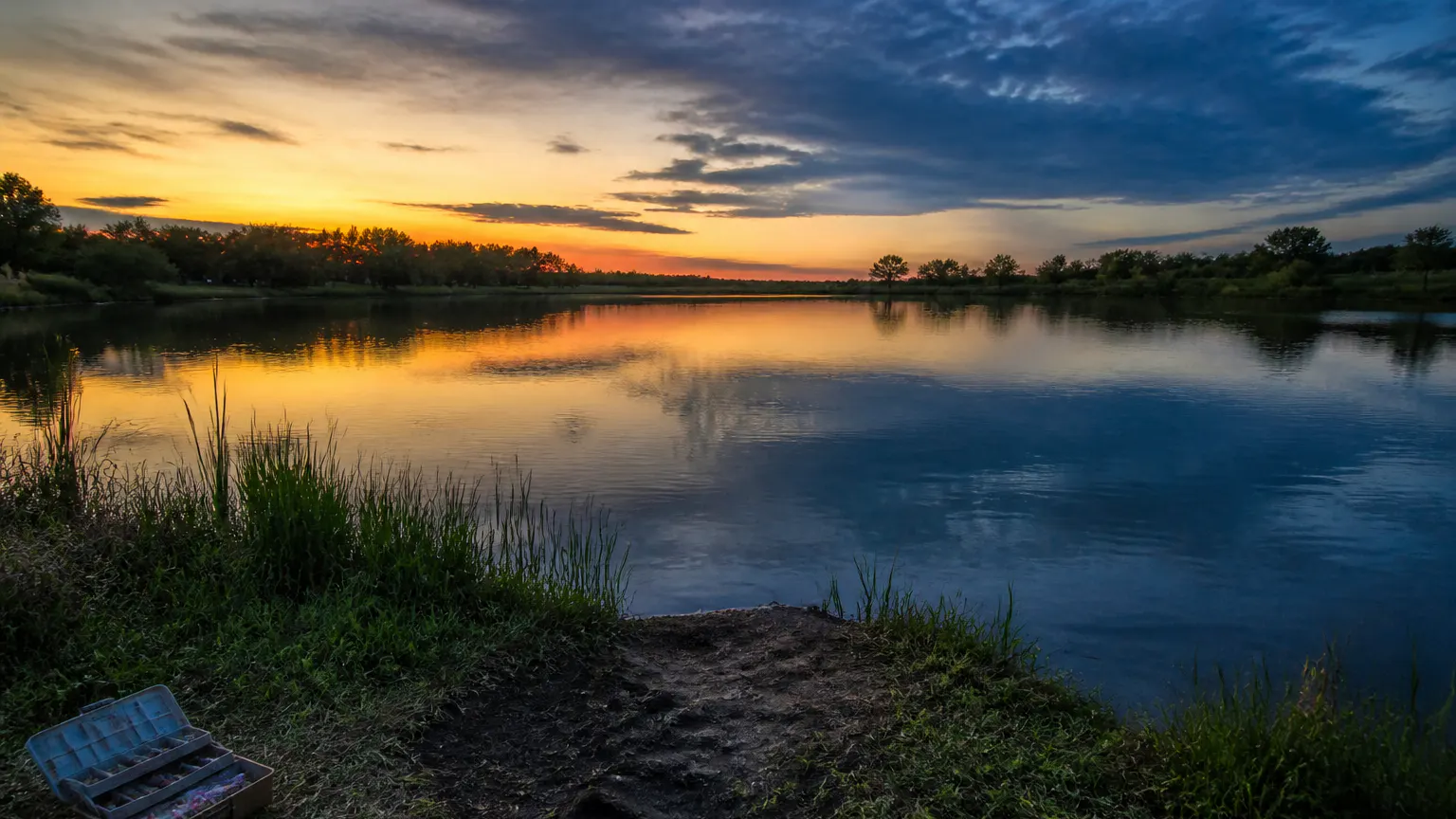 Ventra RC fishing boat out on a dusk lake dropping bait far from shore