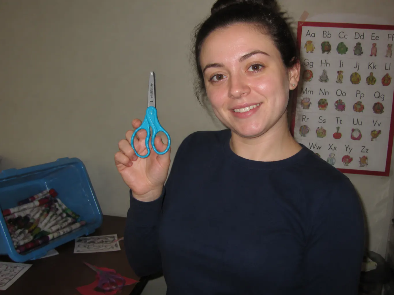 A classroom craft table with scissors and coloured paper