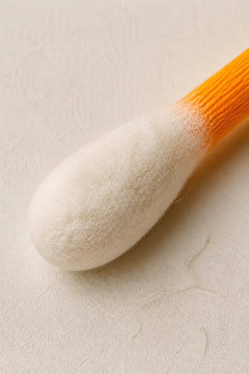 Close-up of the soft felt and tightly-woven cotton bulb with the visible orange fabric core