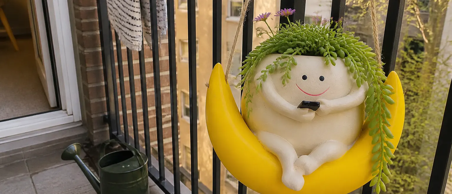Swing planter with a grown-in succulent swinging from a branch in golden-hour light against a softly shaded wall