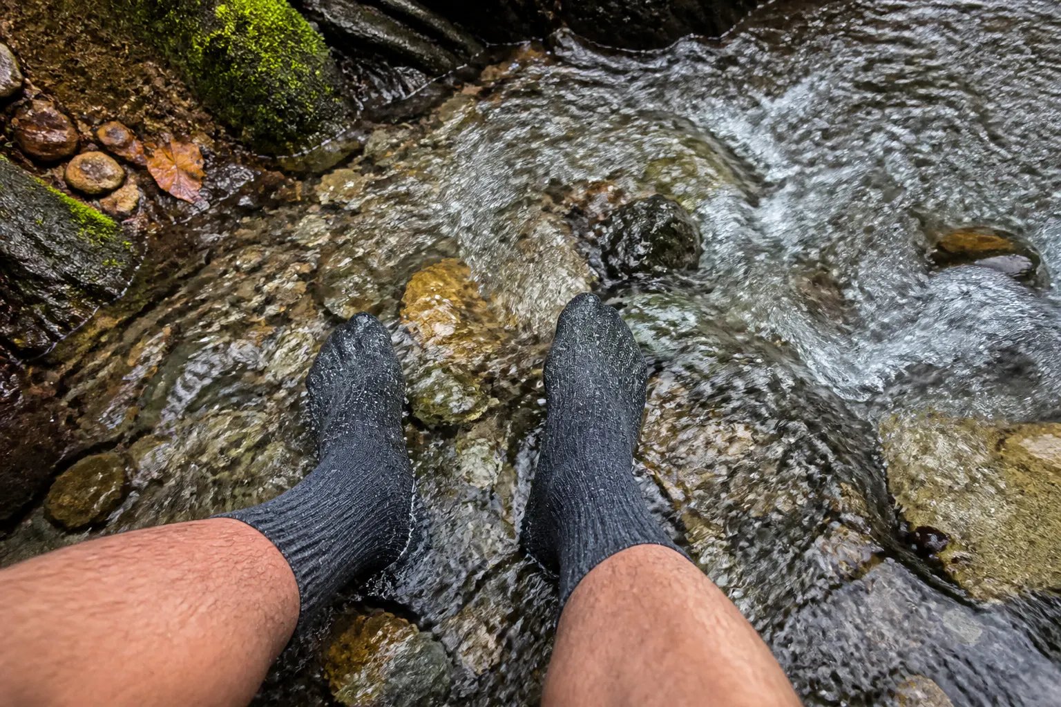 Waterproof sock submerged in moving water, foot dry inside