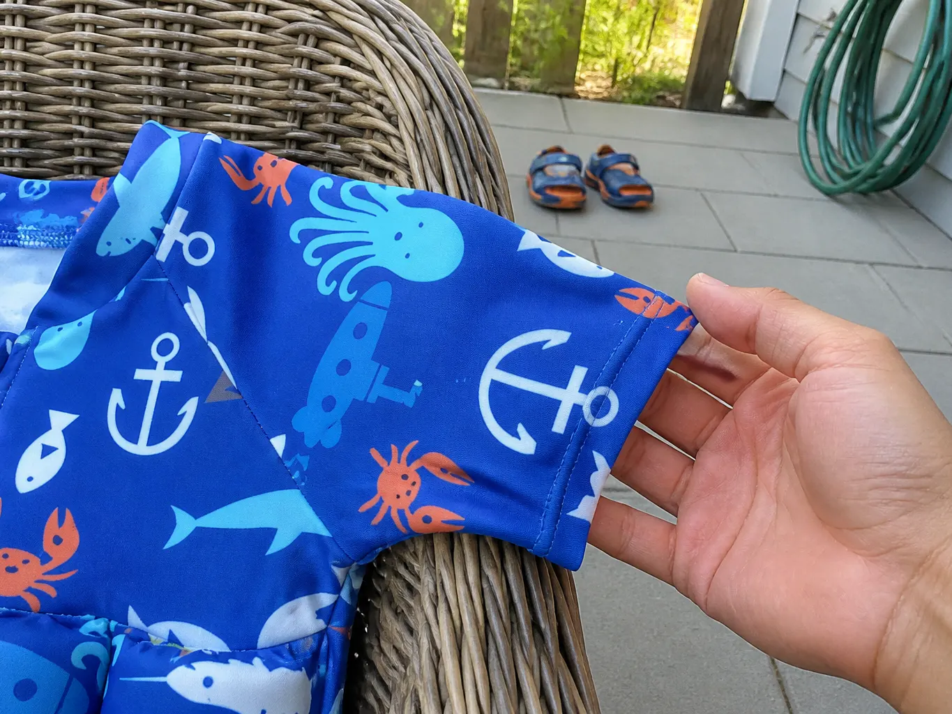 Delighted toddler paddling in a float suit