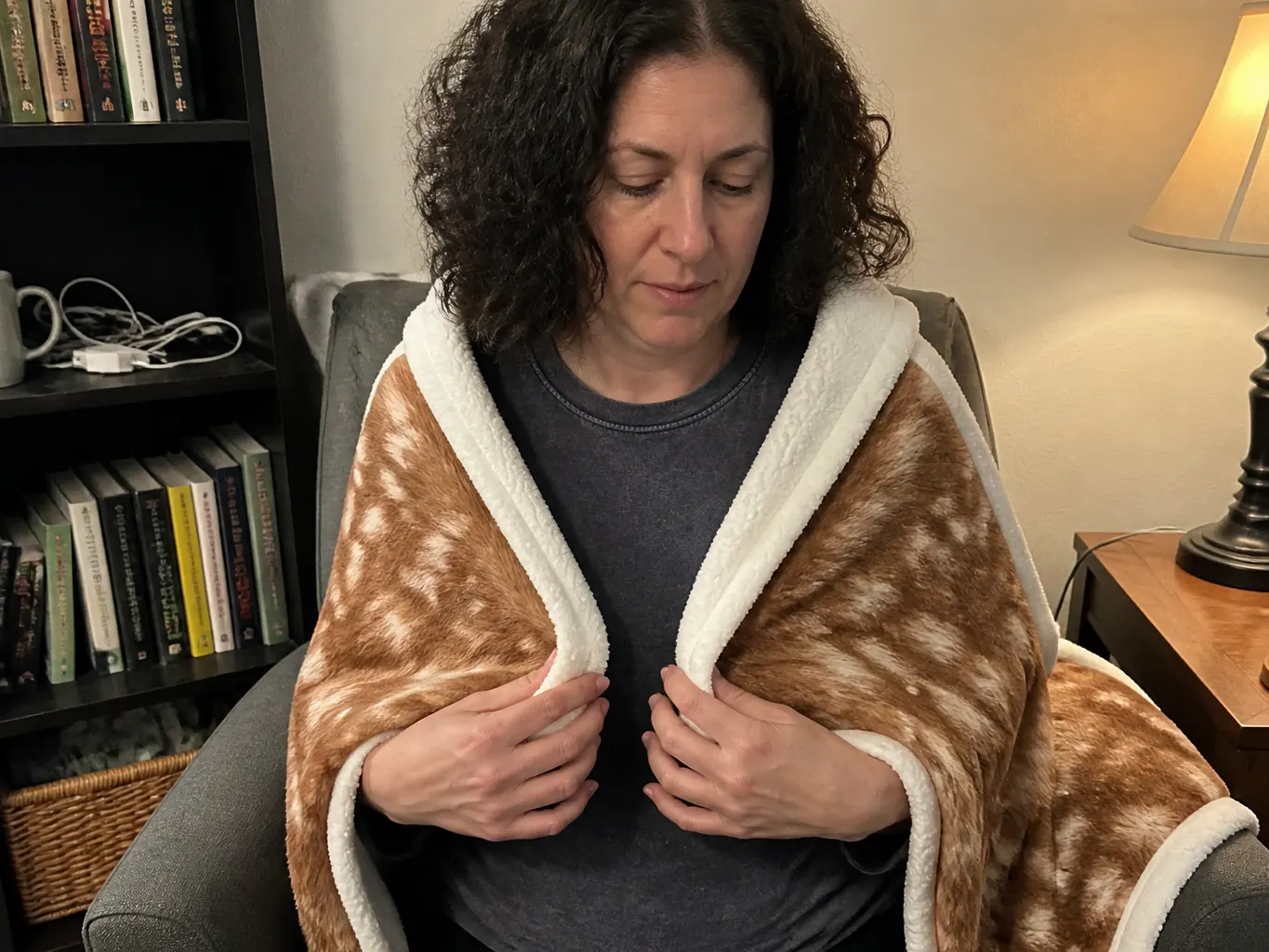 A woman wrapped in the CabinThrow on a couch at night, not looking at the camera