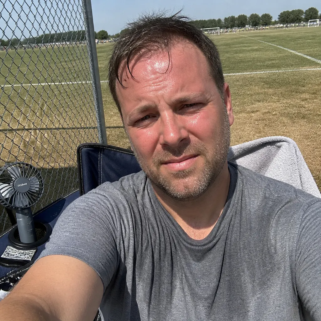 Parent baking on a shadeless hot soccer sideline