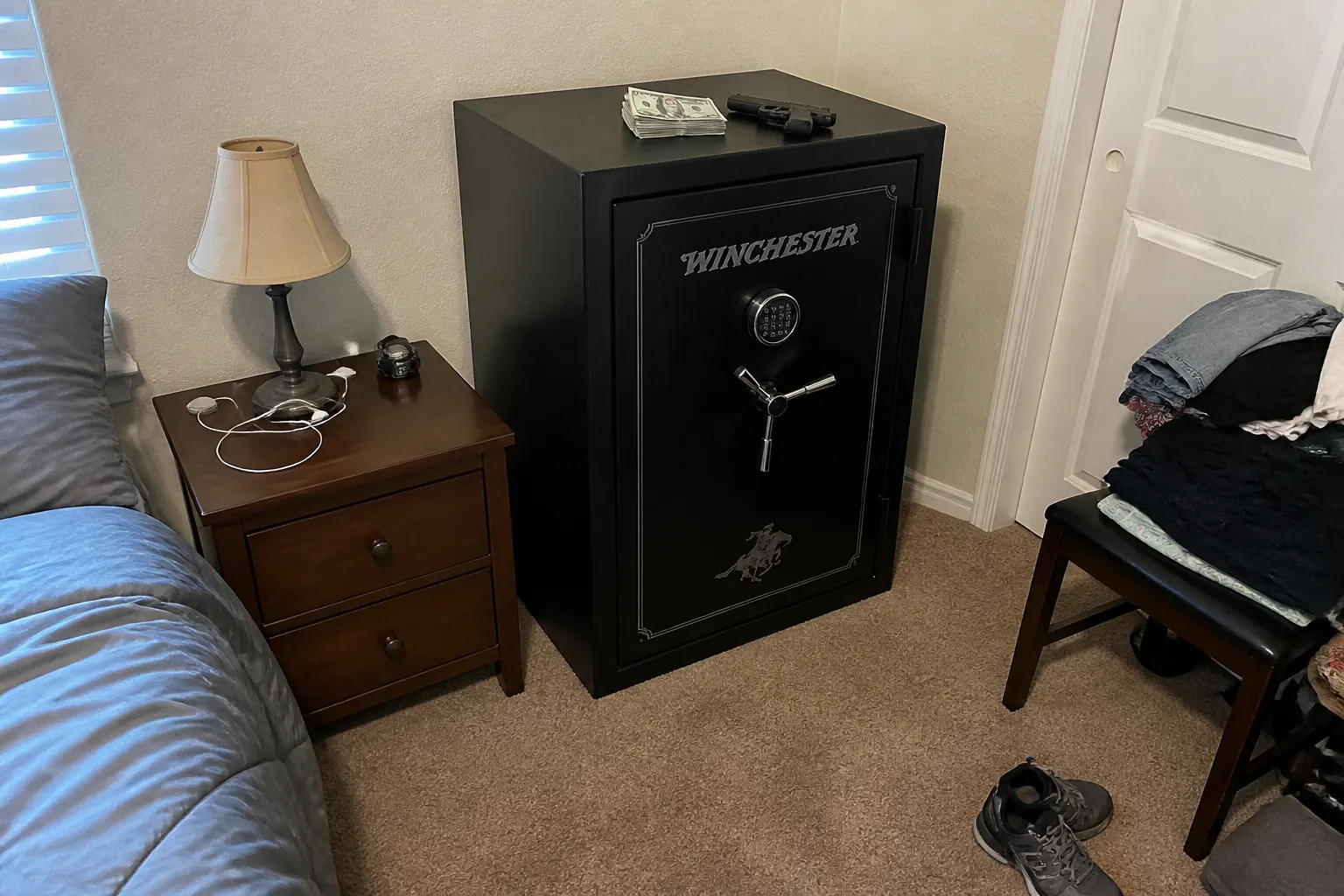 A bulky metal safe or exposed gun on a nightstand, obvious in the room