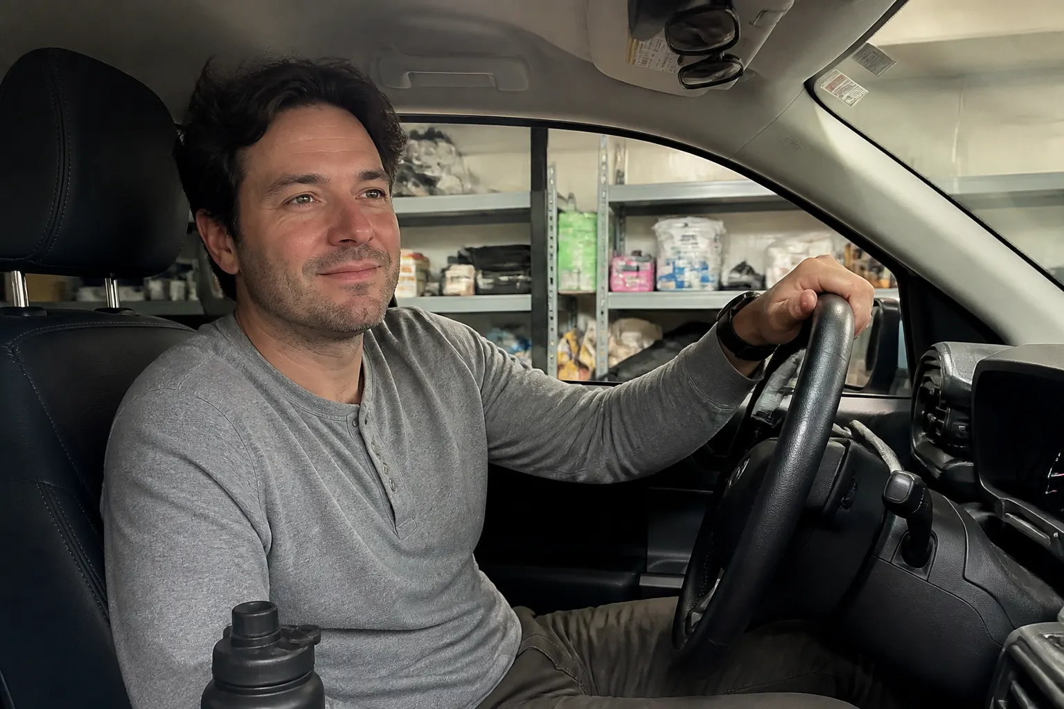 Driver relaxed at the wheel of a shaded, comfortable car cabin