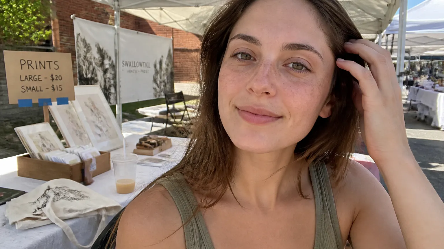 A woman with natural-looking freckles outdoors in warm daylight