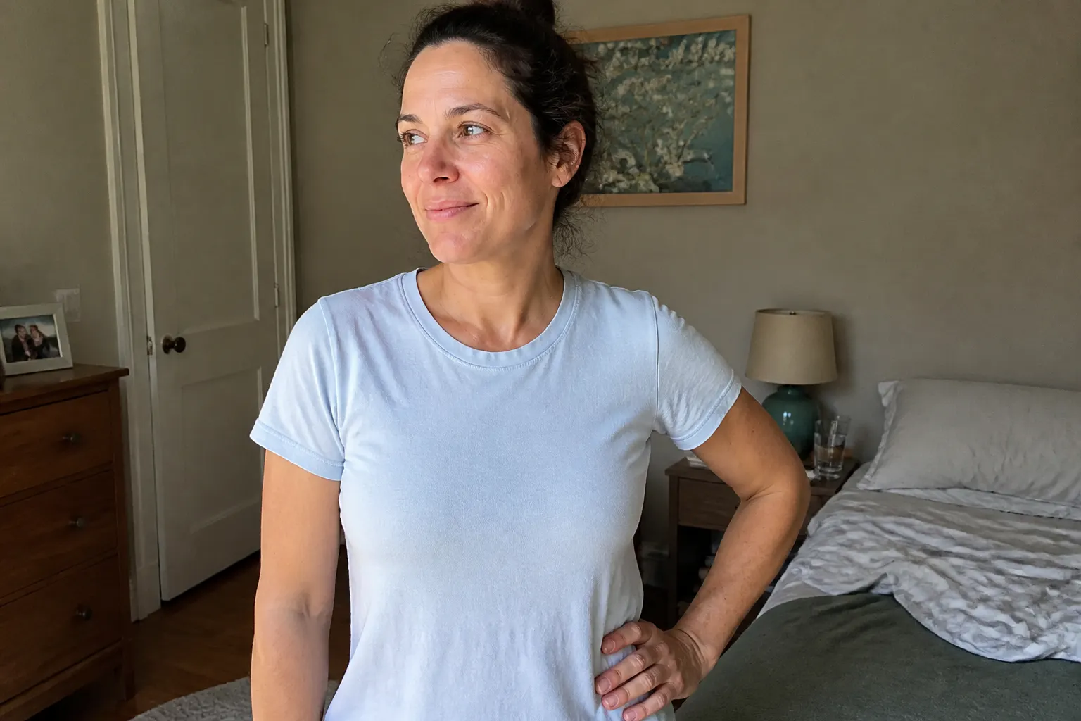 A calm, confident person in a light shirt, arms relaxed