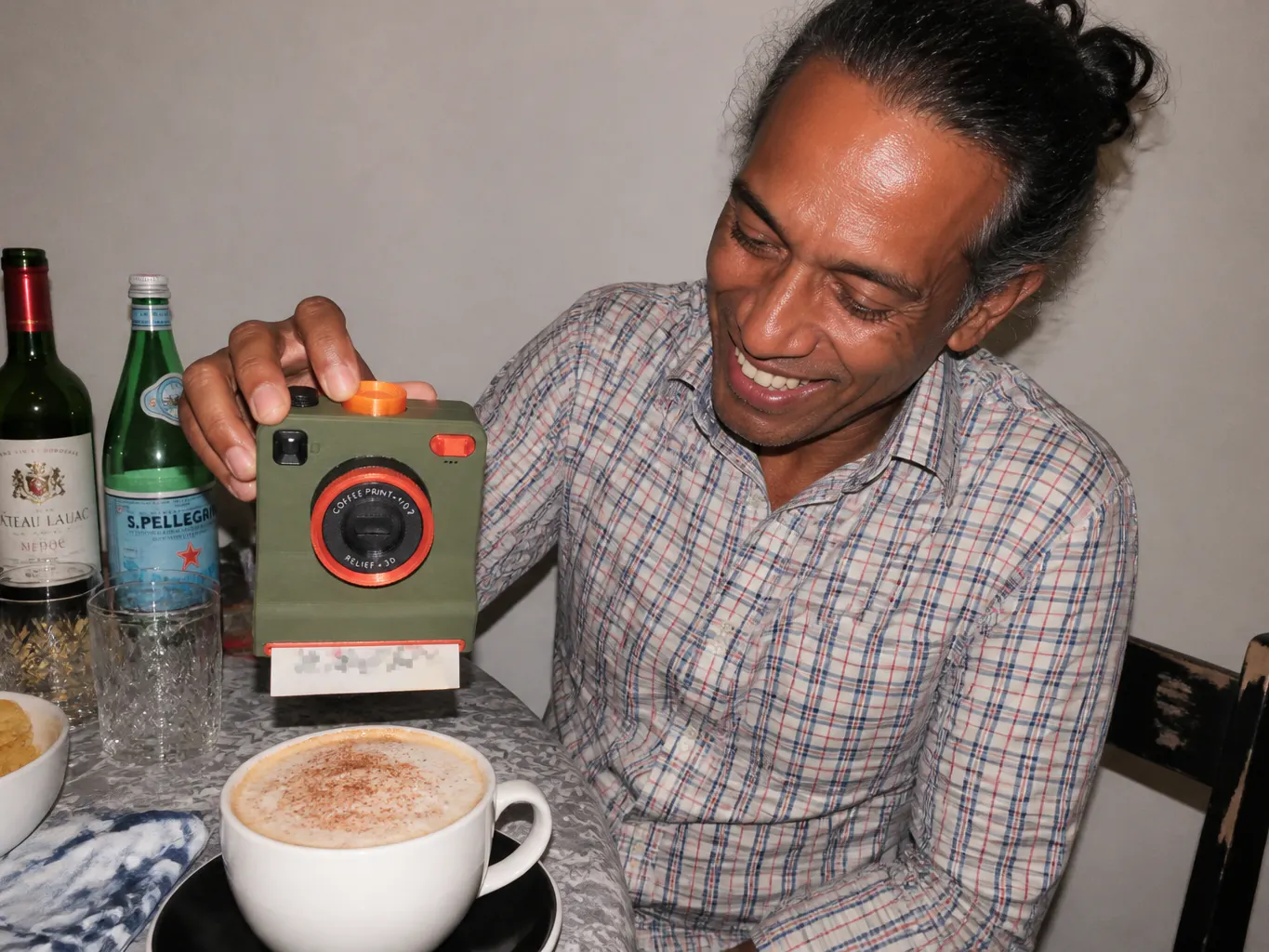 A hand tapping the side of the camera over a filled cup