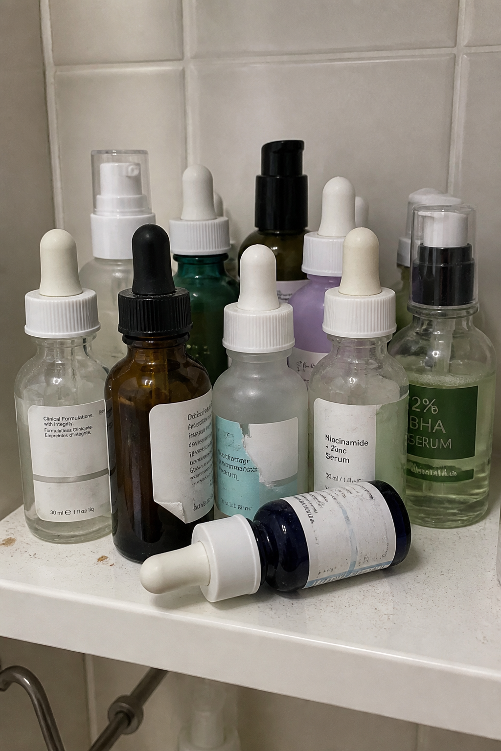 A shelf crowded with half-used serum bottles