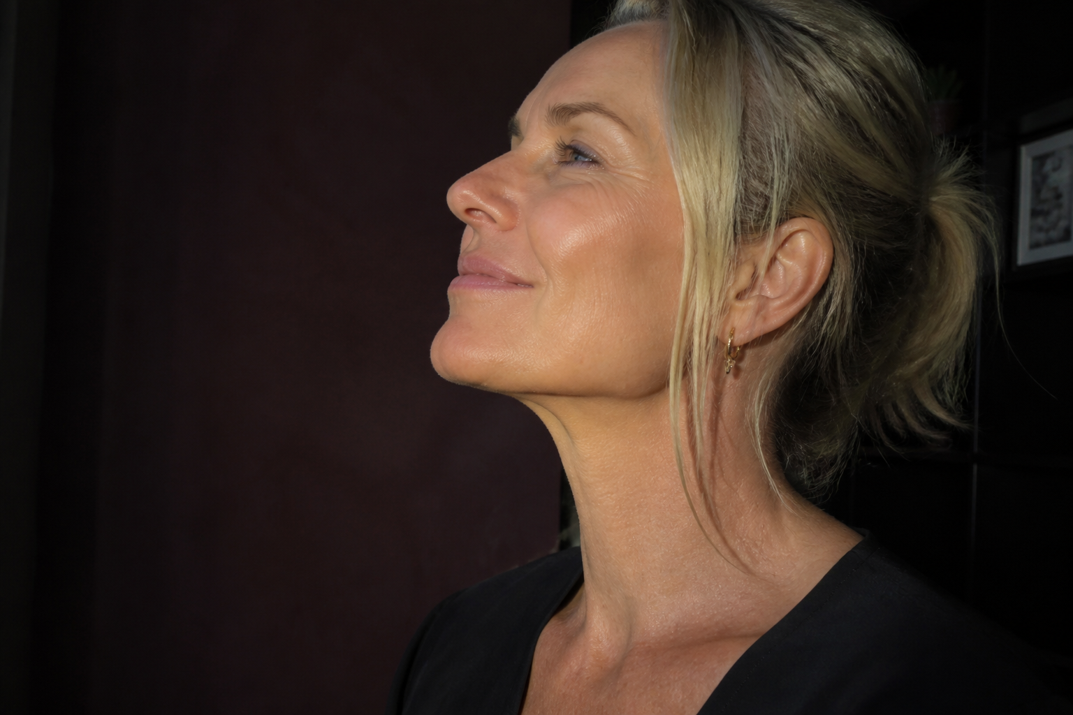A woman with a firm, lifted neck, relaxed and confident at night